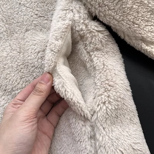 Close-up of side pocket on off-white fleece jacket showing soft texture and stitching