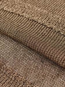 Macro detail of the bronze metallic mesh fabric with a fine knitted texture and luster