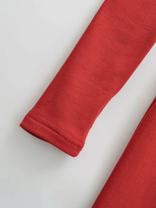 Detailaufnahme der roten Strickärmel mit hochwertiger Doppelnaht-Verarbeitung am Saum