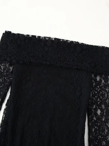 Close-up of black floral lace fabric with off-the-shoulder neckline and intricate texture
