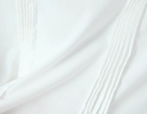 Détail du chemisier blanc avec des plis nervures verticaux et une texture douce