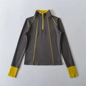 Detail view of sport long-sleeve top with yellow contrast stitching and thumbhole cuffs