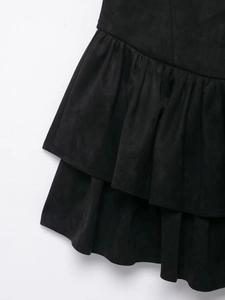 Detailed macro view of layered ruffles and soft suede fabric on the black fashion dress
