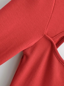 Nahaufnahme der roten Strickkleid-Details mit feinen Nähten und hochwertigem Jersey