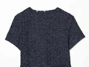 Detail van de blauw-zwarte tweed weefstructuur en ronde hals met maatlabel S