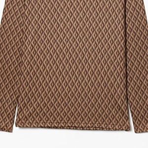 Détail des poignets et de l'ourlet marron à motifs géométriques sur haut thermique de ski
