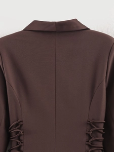 Detail of dark brown blazer back featuring waist lace-up ties and center seam stitching