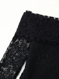 Close-up detail of high-quality black floral lace fabric with intricate cutout patterns