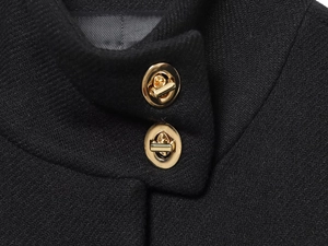 Detalle de cierres giratorios dorados en el cuello de un abrigo de invierno negro