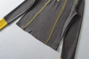 Detail of half-zip grey sports top with yellow contrast stitching and thumbhole cuffs