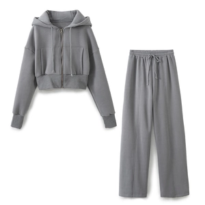Detail of grey knitted tracksuit showing the hood drawstring and metal zipper texture