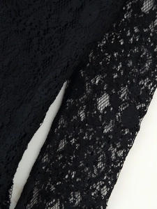 Close-up of black lace fabric showing intricate hollow floral patterns and mesh texture