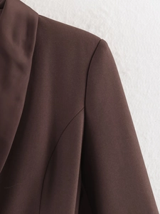 Detailed view of dark brown woven fabric and clean stitching on a chic winter blazer