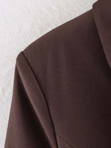 Detailed macro shot of dark brown winter blazer fabric showing high-density stitching