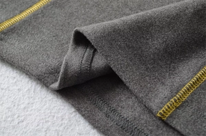 Detail of dark gray thermal fabric with contrasting yellow decorative overlock stitching