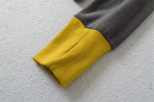 Detail of grey thermal top featuring mustard yellow ribbed cuffs with functional thumbholes