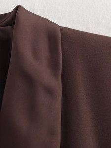 Detailed macro shot of brown twill fabric lapel on a modern women's fashion blazer