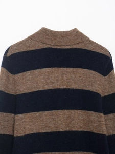 Détail du tricot rayé marron et bleu marine et du col montant d'un pull en laine