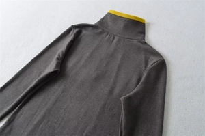Detail of dark grey thermal top featuring contrast yellow trim on the stand-up collar