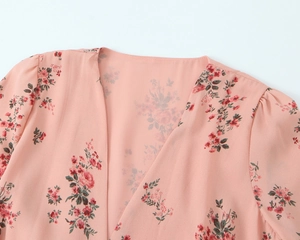 Detail of V-neckline and puff sleeve on pink floral chiffon dress with sharp prints