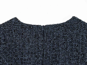 Detail van ronde halslijn en onzichtbare rits aan de achterkant van tweed stof