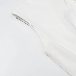Close-up detail of smooth stitching and sleeveless shoulder seams on a white maxi dress
