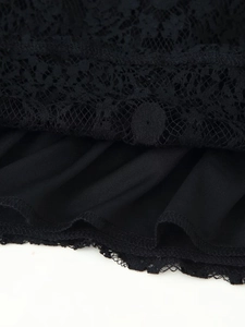 Detailed macro view of black floral lace fabric with precise hemline stitching