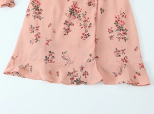Close-up of pink floral chiffon dress featuring elegant ruffle hem and rose pattern