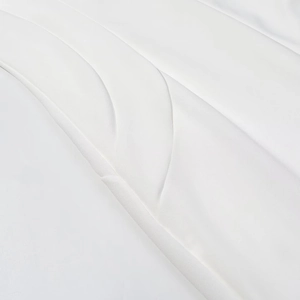 Close-up of high-quality white pleated fabric detail showing fine texture and sewing