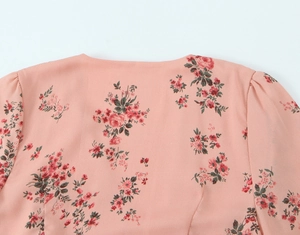 Detail of pink floral dress featuring pleated shoulder, puff sleeves and V-neckline print