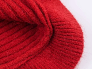 Macro detail of red ribbed knit fabric showing soft texture and high-quality wool yarn