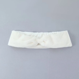 Gros plan sur un bandeau en peluche blanche avec nœud torsadé en flanelle douce