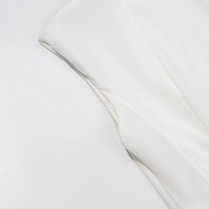 Close-up of fine fabric texture and neat stitching on white backless maxi dress