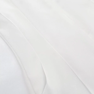 Detailed macro view of pure white fabric texture and soft drapes of the long dress