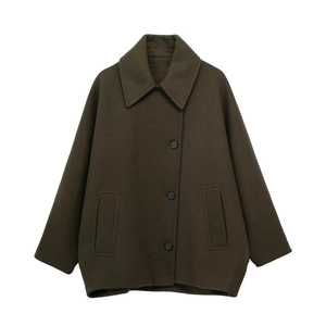 Detailed close-up of dark olive wool blend coat featuring notched lapels and asymmetric buttons