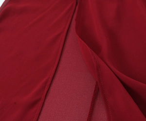 Dettaglio dello spacco laterale dell'abito in chiffon rosso con doppie cuciture rifinite