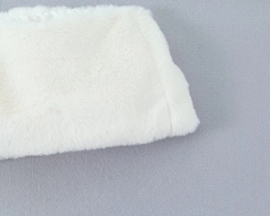 Détail d'un col en fausse fourrure blanche douce avec une texture de poils longs et soyeux