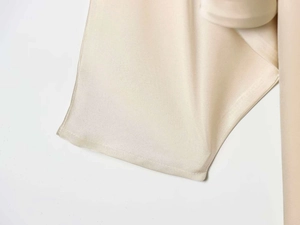 Gros plan d'une robe en satin de soie champagne montrant la texture et les coutures