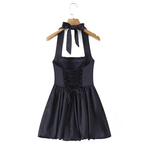 Detail of satin backless dress featuring large neck bow and corset style lacing