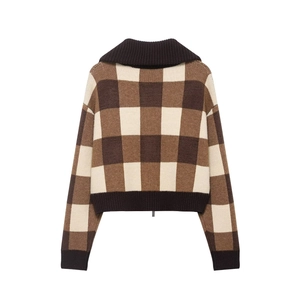 Detail of plaid knit sweater featuring a brown checkered pattern and ribbed cuffs