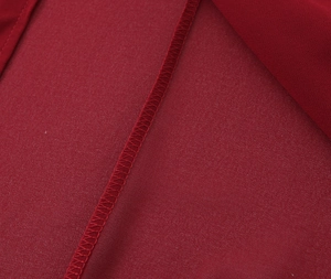 Dettaglio ravvicinato delle cuciture overlock di qualità sul tessuto dell'abito rosso