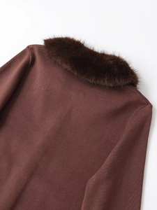 Close-up of faux fur collar and textured knit fabric on a stylish winter top