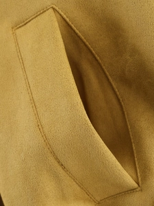 Detail of camel suede bomber jacket showing side pocket stitching and fabric texture