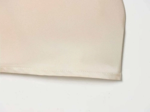 Détail de l'ourlet et de la texture en soie sergé de la robe beige élégante