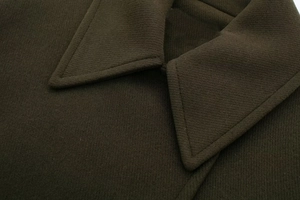 Detail of olive green wool coat collar featuring premium textured twill fabric and stitching
