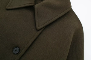Macro detail of high-quality wool blend fabric texture and button on olive coat
