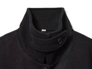 Close-up of a stand-up collar with buttoned windproof strap on a black wool coat
