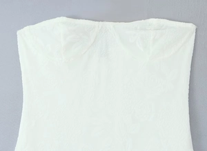 Vue détaillée du haut bustier blanc présentant une élégante texture en jacquard fleuri