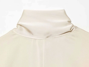 Gros plan sur une robe en satin de soie ivoire avec col montant et texture premium