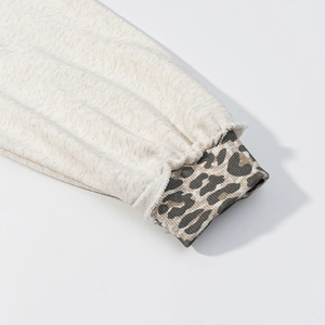 Close-up of animal print ribbed cuffs and raw edge stitching on grey hoodie